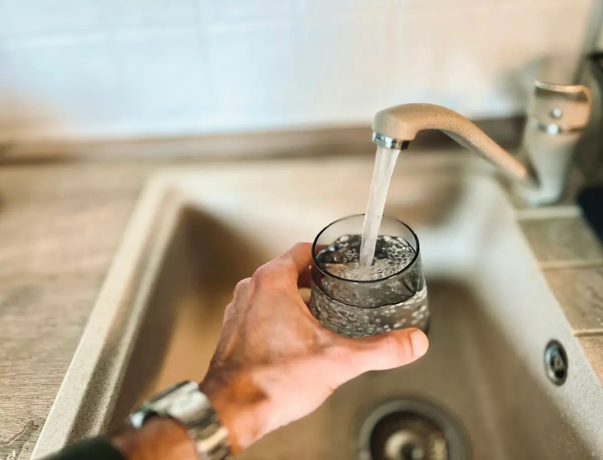 A glass being filled at a kitchen tap, free in-home water test in west Broward